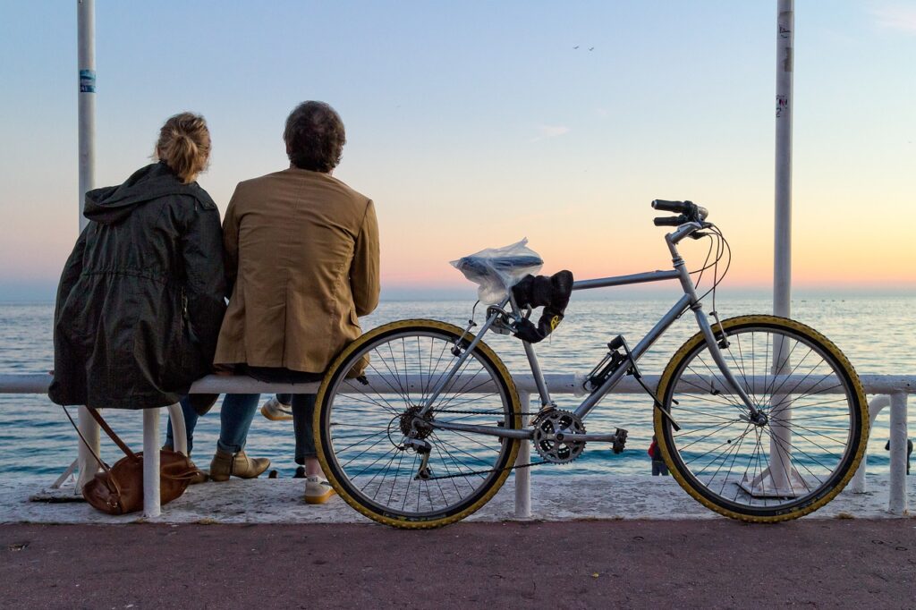 Couple sitting by ocean view with bicycle